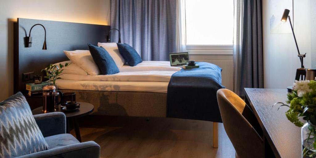 莱旺厄尔Thon Partner Hotel Backlund的一间卧室配有一张带蓝色枕头的大床