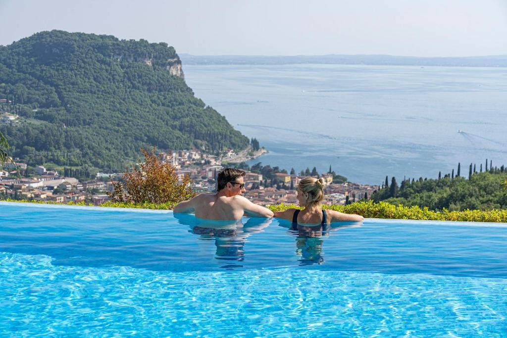 科斯特曼诺Madrigale Panoramic Lifestyle & Soulful Hotel的站在游泳池中的男女