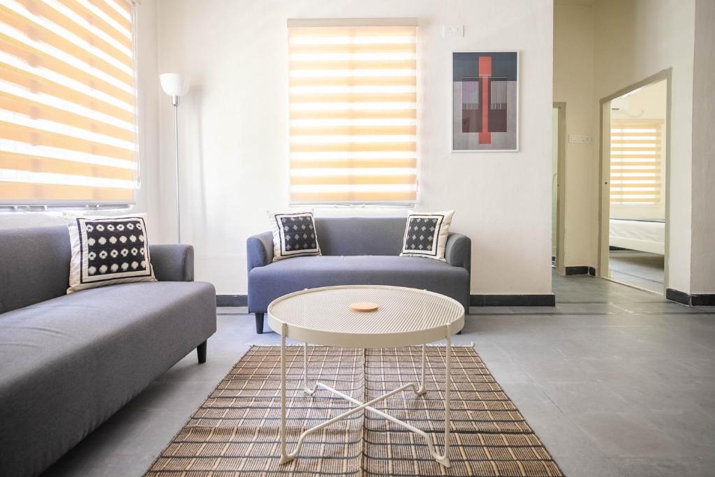 海得拉巴Neemtree Apartments的客厅配有两张沙发和一张桌子