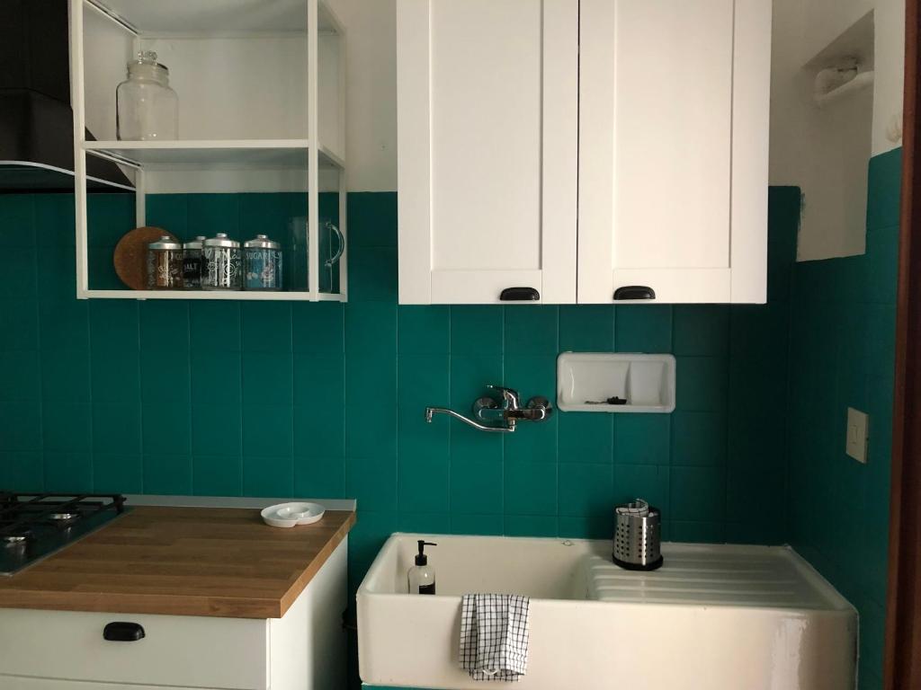 佩萨罗FAMILY HOME的绿色厨房配有白色橱柜和浴缸
