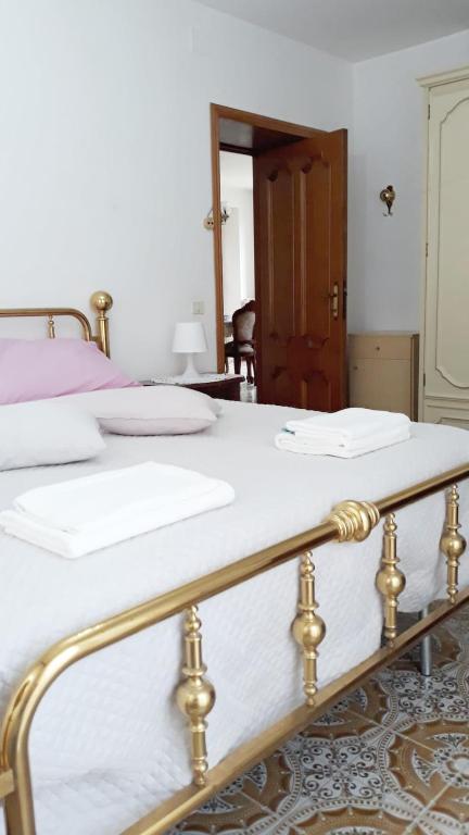 PennapiedimonteLocation Serafina Pennapiedimonte的卧室内的两张床,配有白色床单和金色栏杆