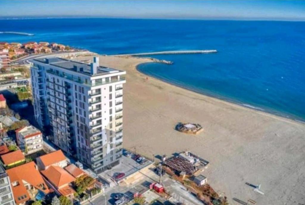 康斯坦察Faleza Nord apartament de lux nou pe malul marii的享有海滩和大楼的空中景致