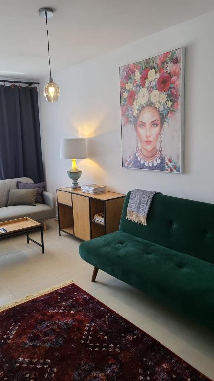 奥尔什丁Apartament Mochnackiego的客厅配有绿色沙发和绘画作品
