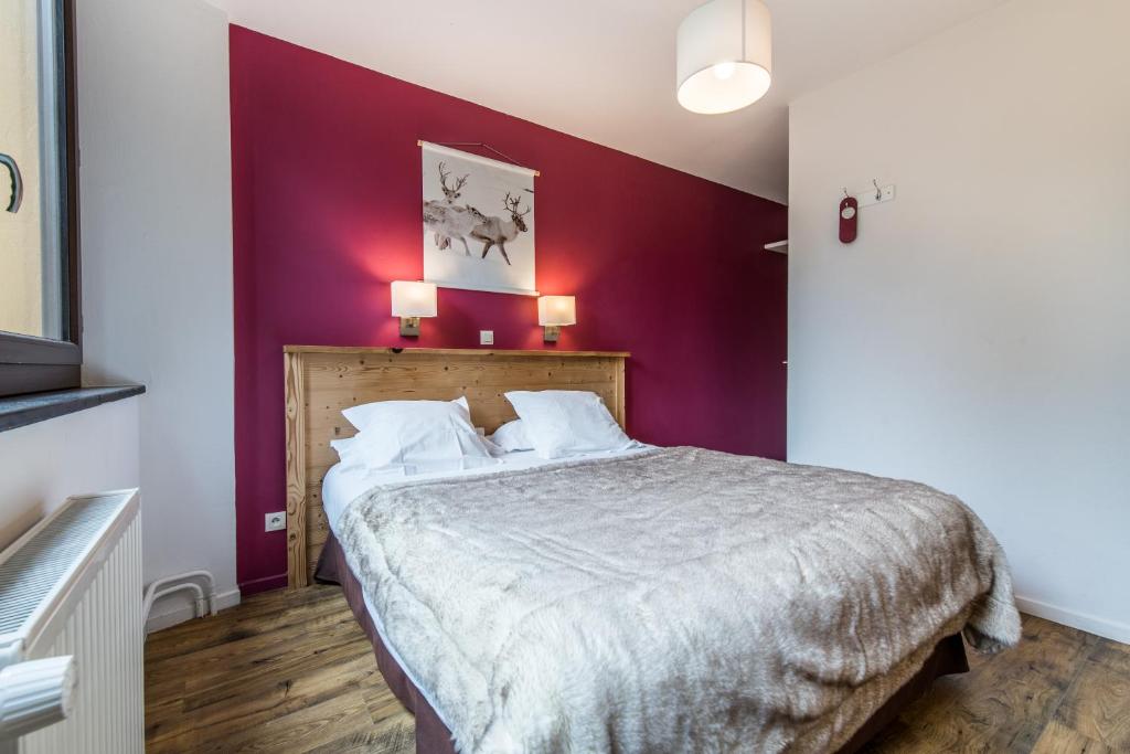 圣米歇尔德莫里耶讷马林坦酒店的一间卧室配有一张紫色墙壁的床