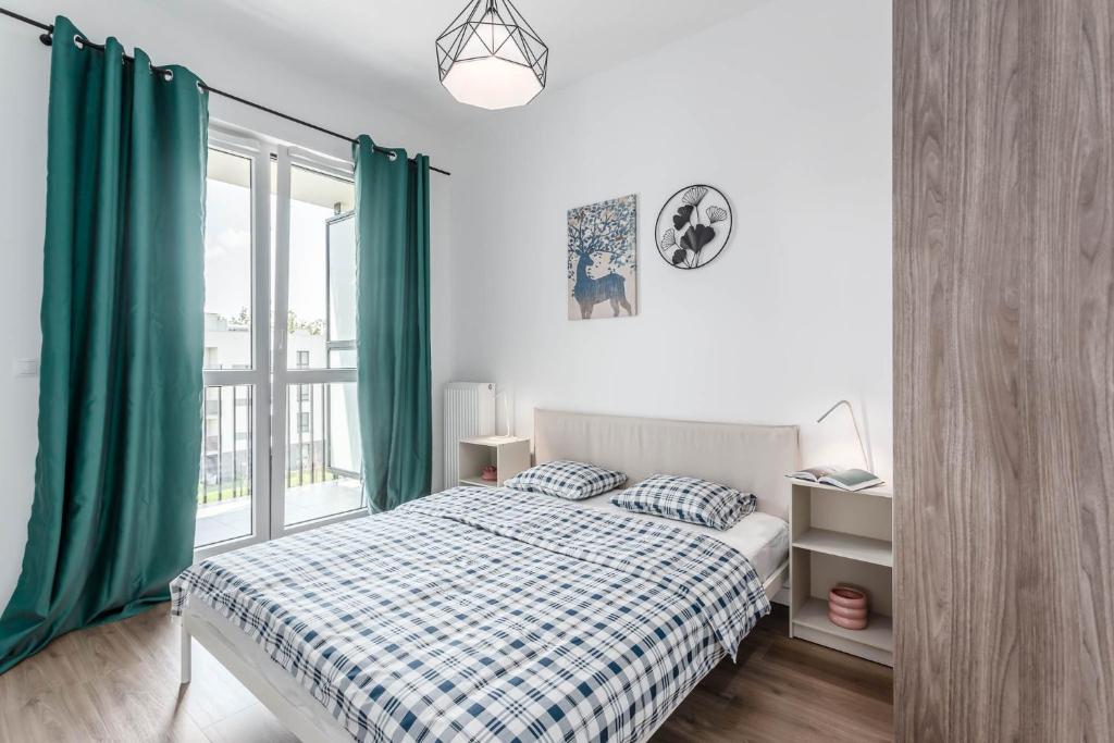 华沙Chill Apartments Ursynów Premium的一间卧室配有一张带绿色窗帘的床和窗户。