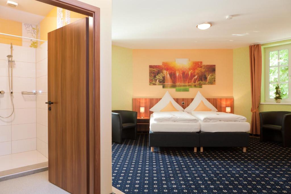 巴本豪森度茨车霍夫酒店的酒店客房设有两张床和淋浴。