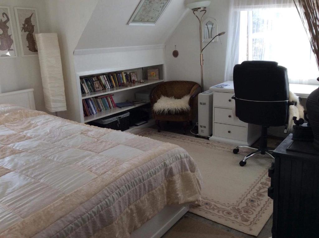 SaudaBed and breakfast的一间卧室配有一张床、一张桌子和一把椅子