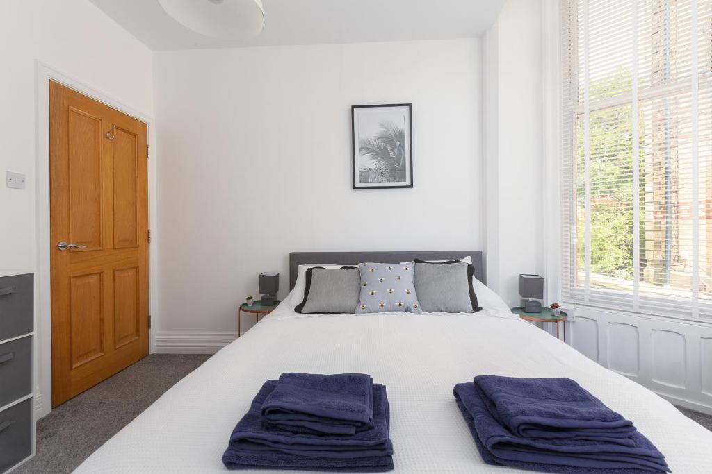 莱瑟姆-圣安妮Charles Alexander Short Stay - Clifton Drive Beach Retreat的一间卧室配有一张带2条蓝色毛巾的床