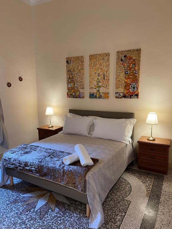 利沃诺Intero appartamento 3 letti con garage gratuito的一间卧室配有一张带两盏灯和两张照片的床。