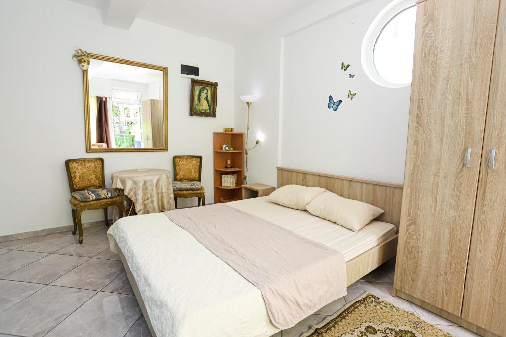 赫尔采格诺维Guest House Topla的一间卧室配有一张床、镜子和一张桌子
