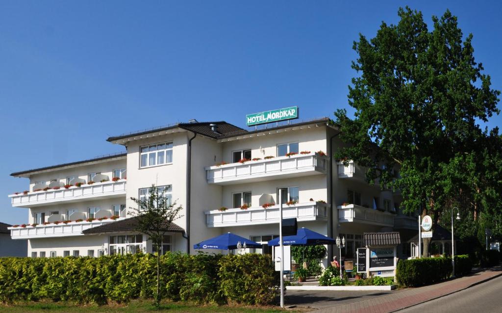 卡尔斯哈根诺德卡帕酒店的白色的酒店前面有蓝色的伞