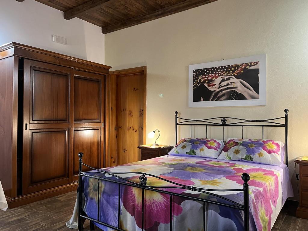 纳尔多Masseria Agriturismo Fontanella的一间卧室配有一张床和一个木制橱柜
