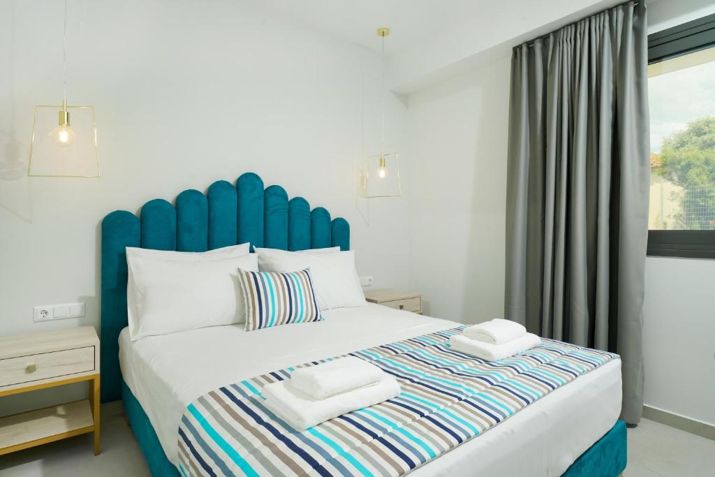 斯卡拉卡里拉奇斯Miracle Suites by Klisma beach的一间卧室配有一张大床和蓝色床头板