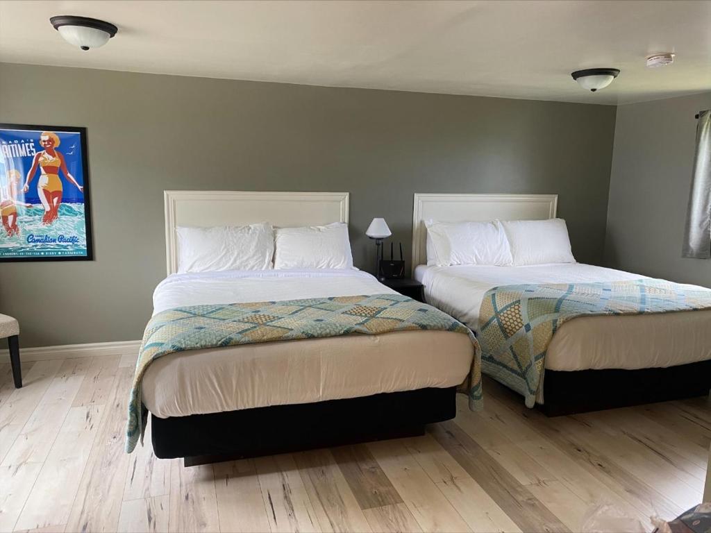 迪格比海风汽车旅馆的一间卧室设有两张床,墙上挂着一幅画