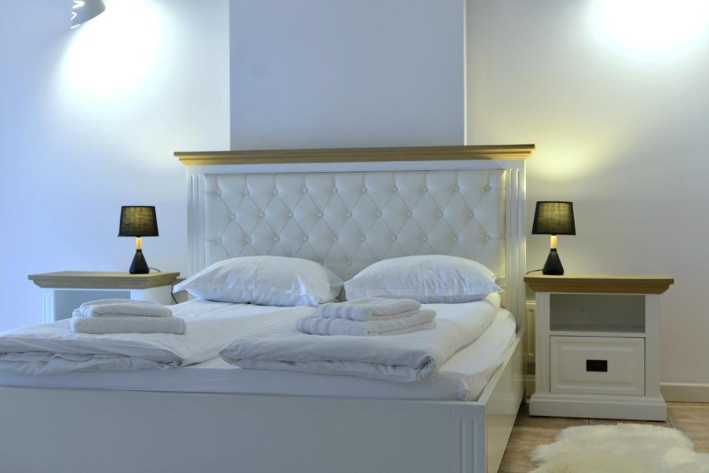 上维谢乌Apartament Central的配有白色枕头和两盏灯的白色床
