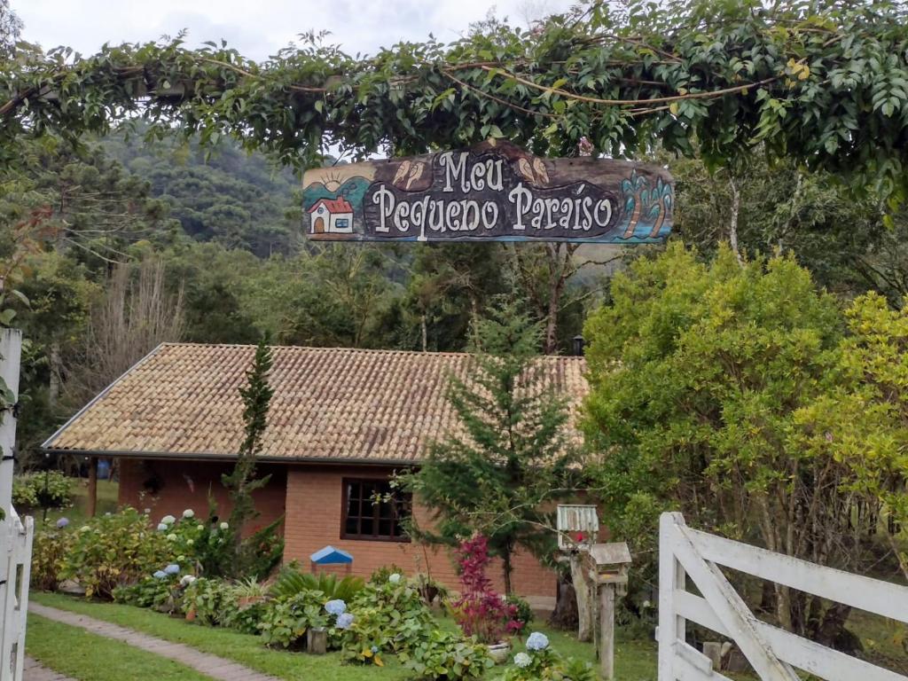 贡萨尔维斯Casa de Campo Meu Pequeno Paraíso的房屋前有栅栏的标志