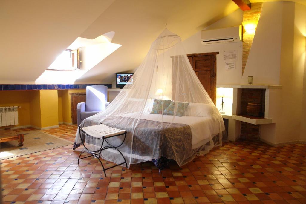 卡索拉Casa Rural Plaza De Santa Maria的一间卧室配有一张带蚊帐的床