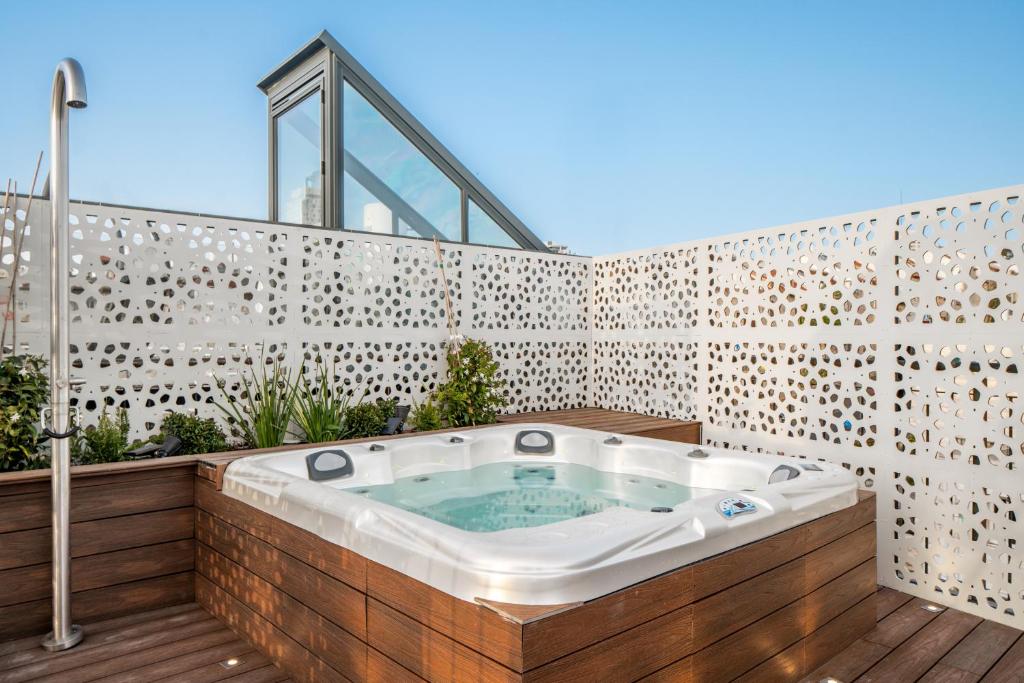 耶路撒冷Albi Boutique Hotel - Traveler's Choice 2024的木制甲板上的按摩浴缸