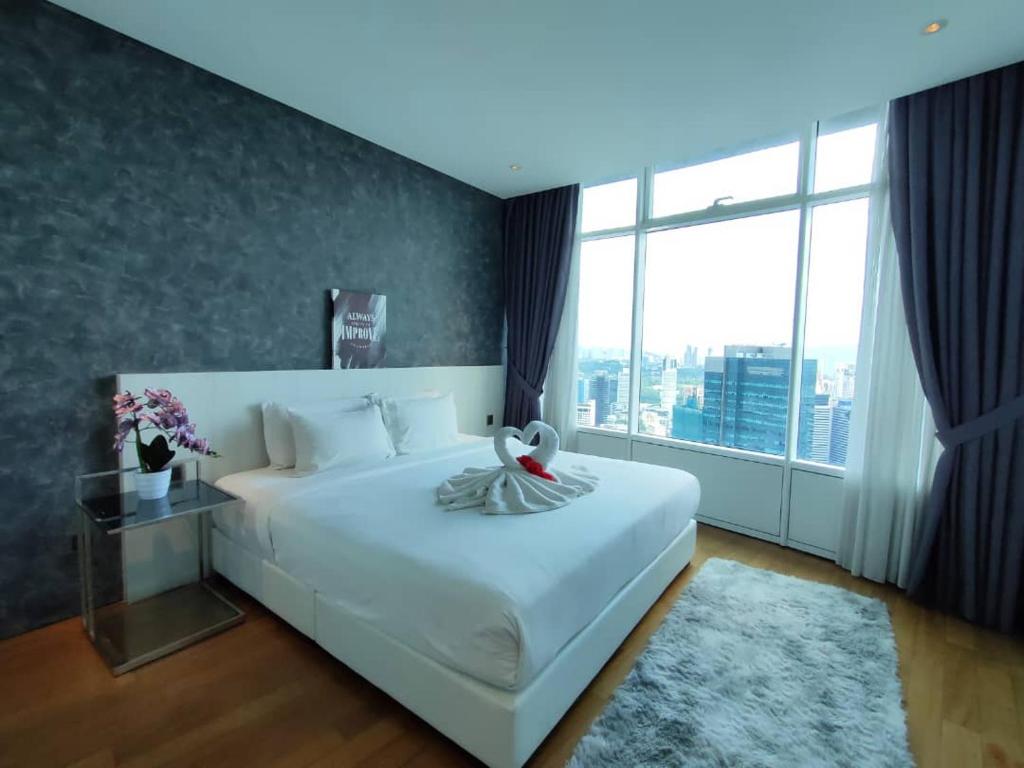 吉隆坡Vortex Suites KLCC by Guesthouse Kuala Lumpur的卧室设有一张白色大床和大窗户