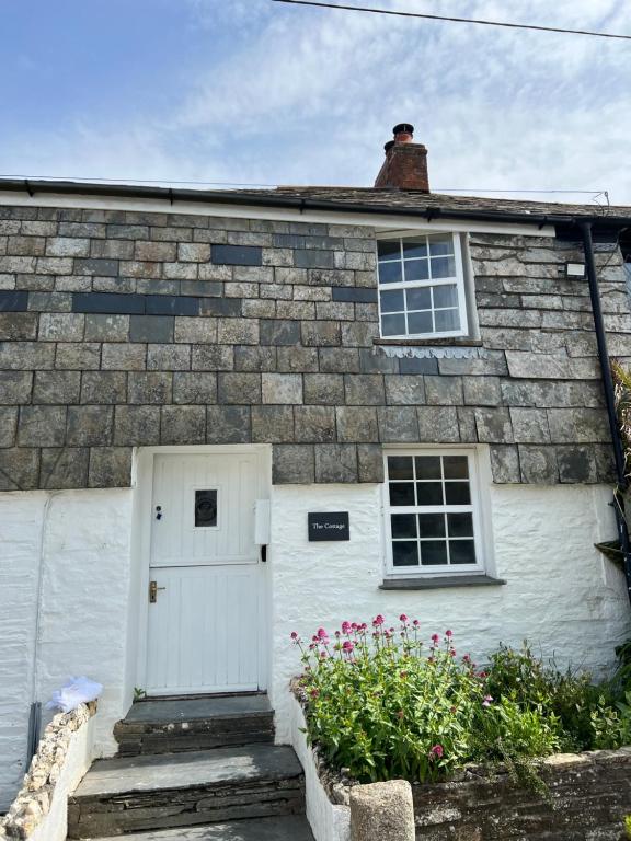 以撒港The Cottage St Kew的砖屋,有白色的门和窗户