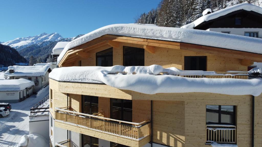 圣安东阿尔贝格ARLhome - Zuhause am Arlberg的雪覆盖的建筑物屋顶