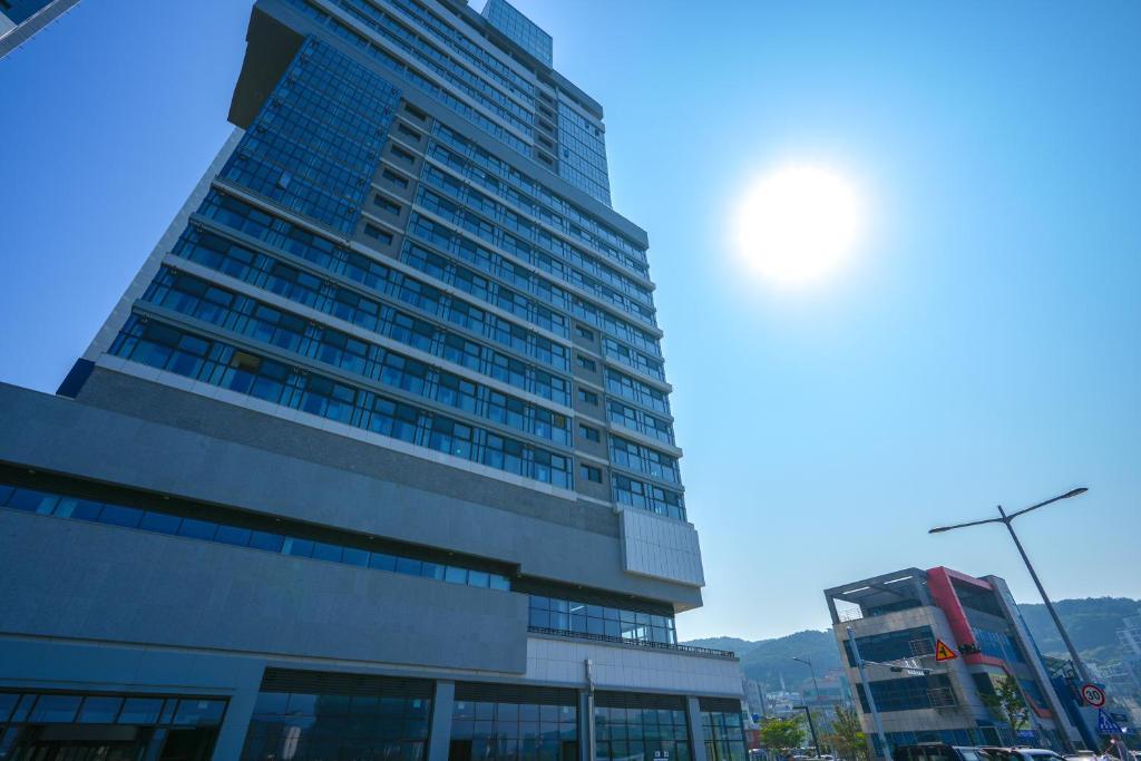釜山Shiftdoor Residence Hari的天空中阳光灿烂的高楼