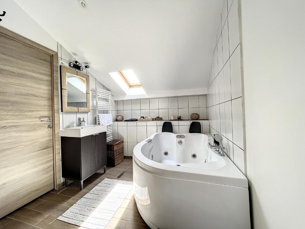 沙勒罗瓦Maison de ville jacuzzi wiffi à 4km aéroport Charleroi的浴室配有大型白色浴缸和水槽