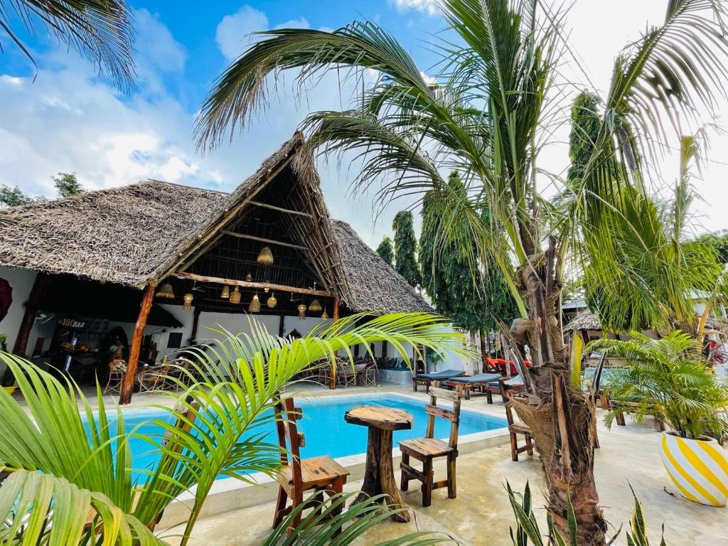南威Babalao Bungalows的一个带游泳池和棕榈树的度假村