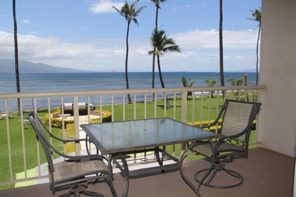 怀卢库Maalaea Kai Resort 213的俯瞰大海的阳台配有桌椅