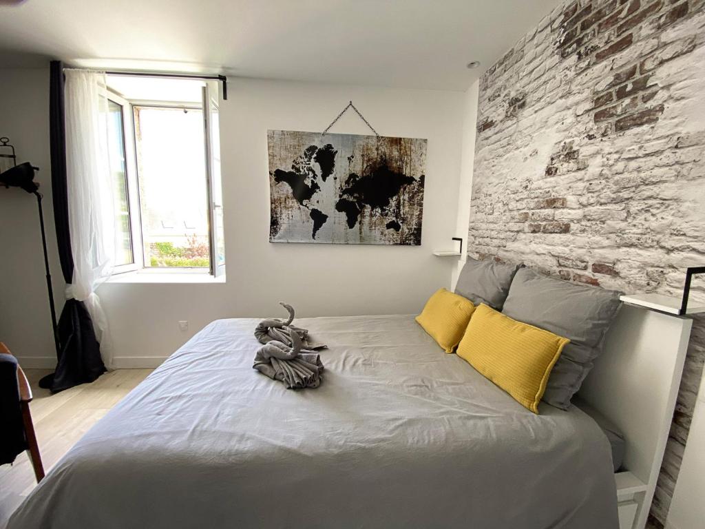 蓬拉贝Le petit atelier - Studio - WIFI - Coeur de ville - Parking的一间卧室配有一张砖墙床