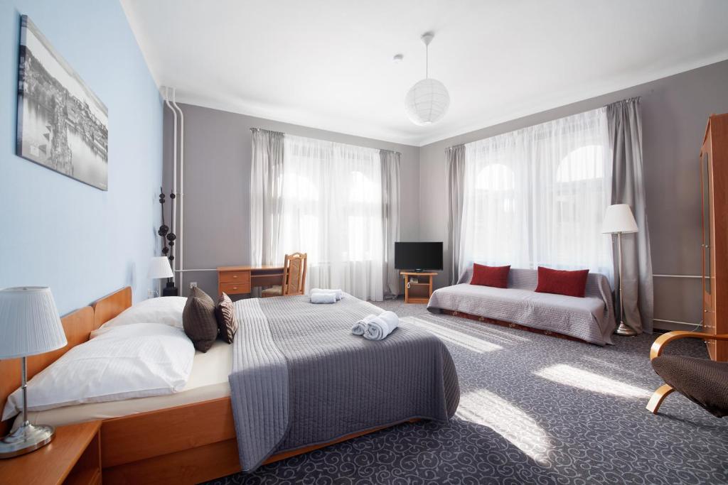 布拉格贝尔城酒店的一间卧室配有一张大床和一张沙发