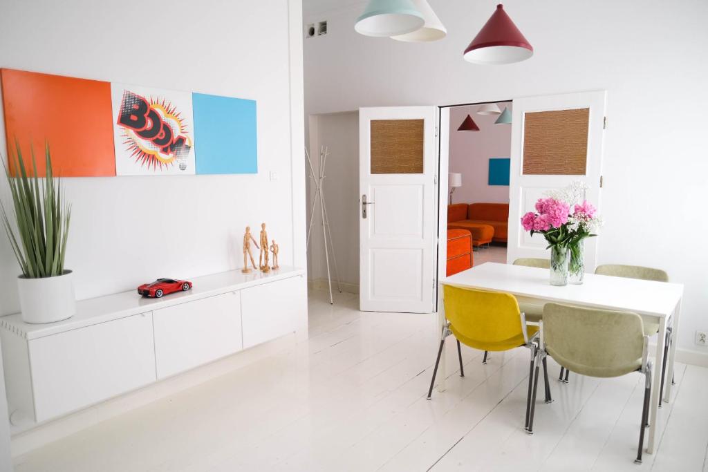 姆拉哥沃Apartamenty Mrągowo Warszawska Cudo Studio的白色的厨房配有白色的桌子和黄色的椅子