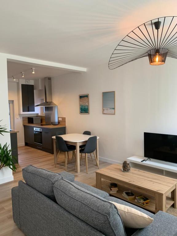 乌尔加特L'Air de la Mer, 2 chambres, 50m plage, parking的客厅配有沙发和桌子