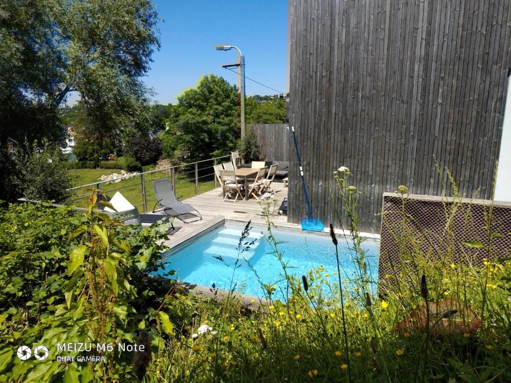 韦尔维耶Maison à la porte des Ardennes的庭院内带桌椅的游泳池