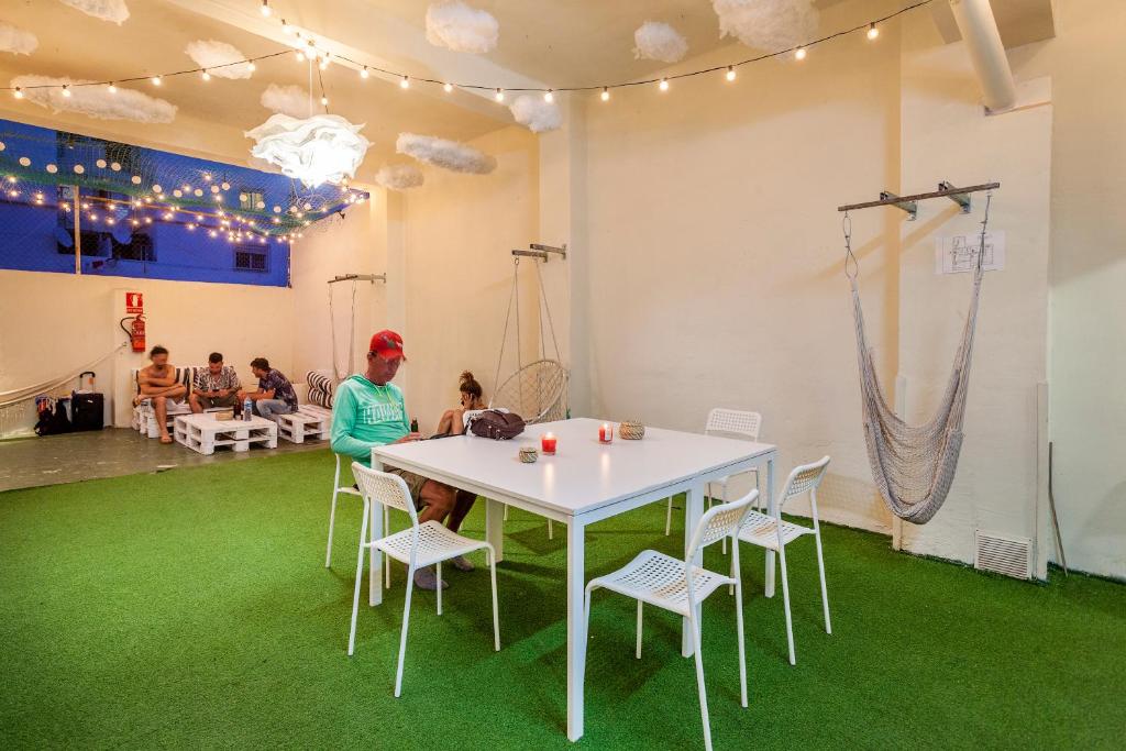 瓦伦西亚Coworking Balance的坐在一张桌子上的人,坐在一间铺有绿色地毯的房间