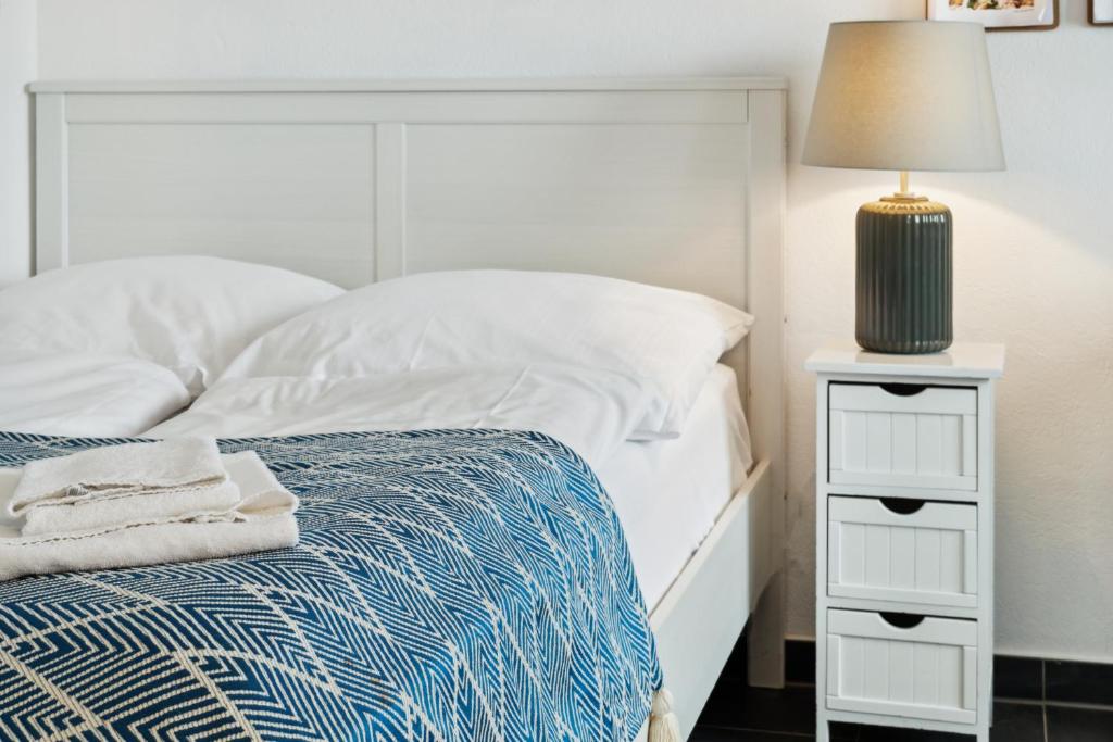 柏林Urban city home的一间卧室配有一张带白色床头板和灯的床