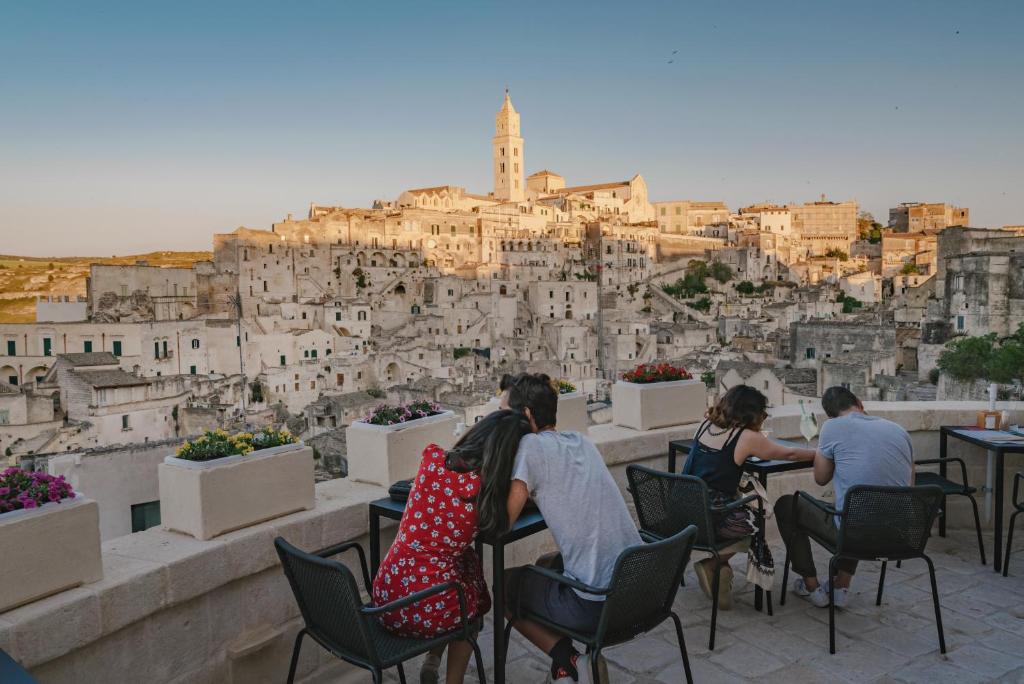 马泰拉德格里阿巴蒂宫殿酒店的一群坐在椅子上的人,看着一个城市