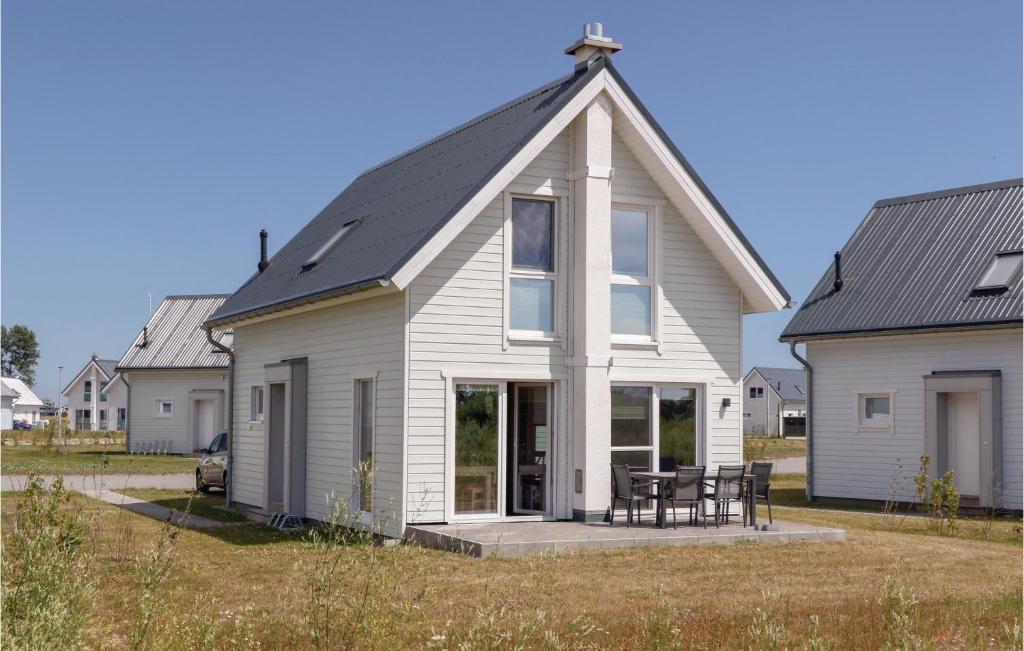 奥尔本尼兹Gorgeous Home In Ostseeresort Olpenitz With Kitchen的黑色屋顶的白色房子