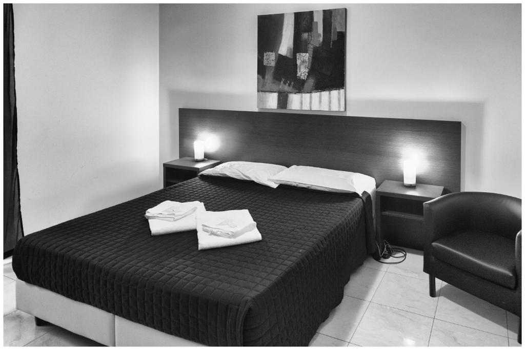 罗马莫赛克旅馆的黑白卧室配有床和椅子