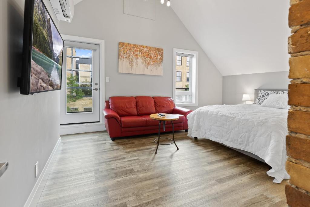 基奇纳ENTIRE 3-UNITS TOP-FLOOR ACROSS FROM GOOGLE的一间卧室配有一张床和一张红色的沙发