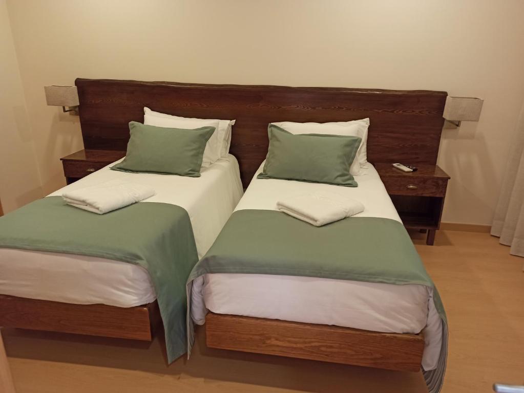 AlpiarçaFontanário House的两张睡床彼此相邻,位于一个房间里