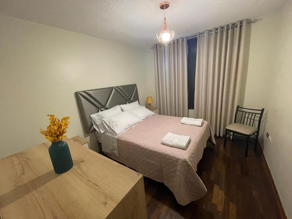 利马Departamento completo Surquillo/Miraflores的卧室配有1张床、1张桌子和1把椅子