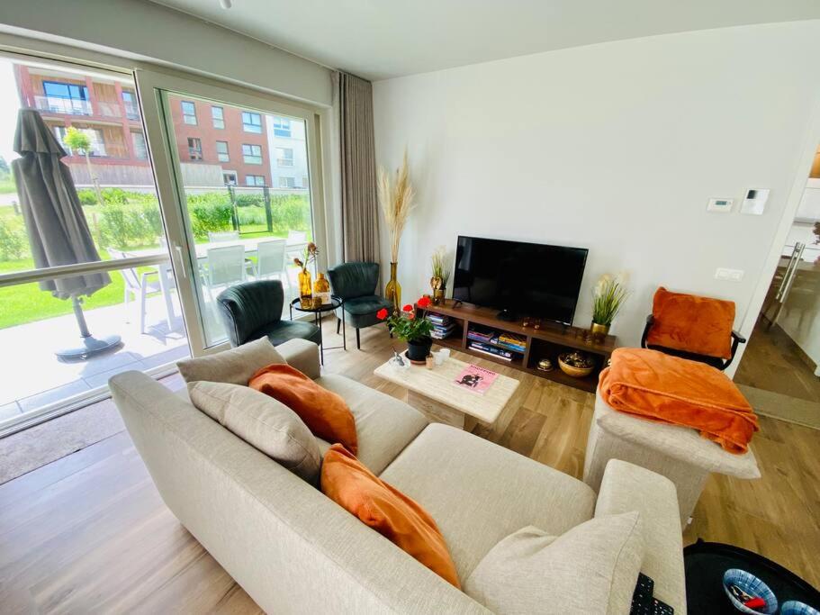HarelbekeLuxury apartment "Volmolen" with garden, terrace and free parking的带沙发和平面电视的客厅