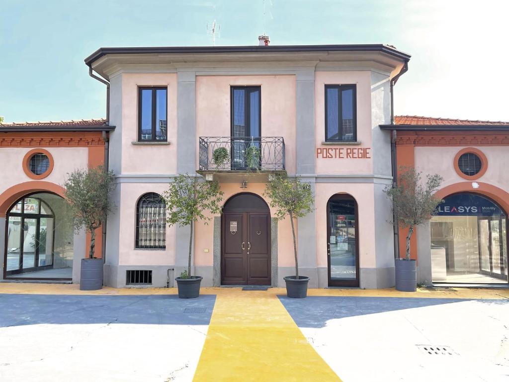 米兰Poste Regie - Milan Guest House的前面有树木的粉红色房子