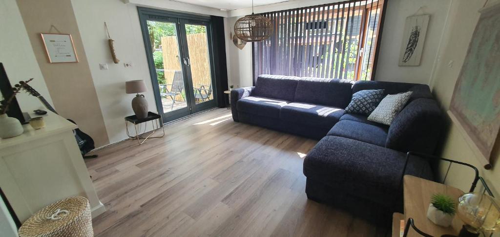 DoornspijkChalet 11, in het bos的客厅设有蓝色的沙发和木地板