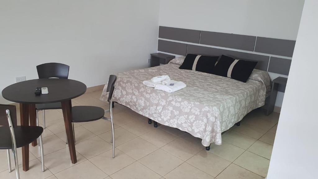 萨尔塔Urquiza的一间卧室配有一张带桌椅的床