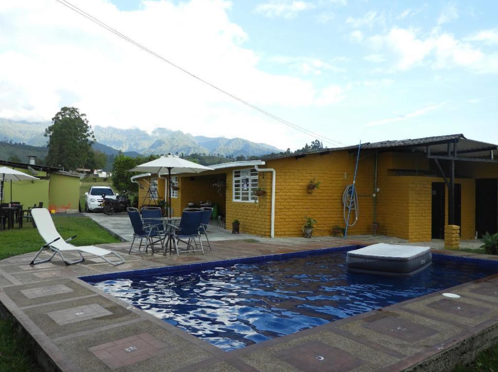 圣罗莎德卡瓦尔Hostal San Ramon的房屋前有游泳池的房子