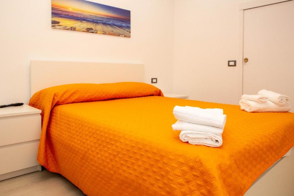 拉古萨码头Endless Summer Apartment的一间卧室配有橙色床和毛巾