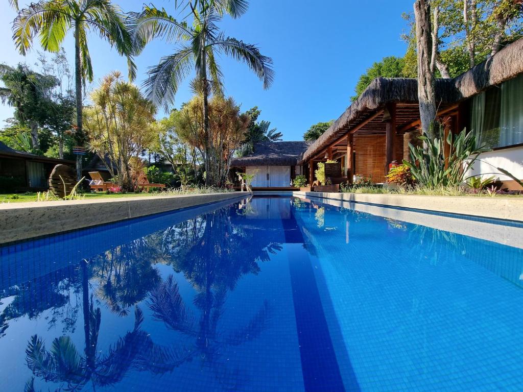 阿拉亚尔达茹达Villa Bulan的棕榈树屋前的游泳池