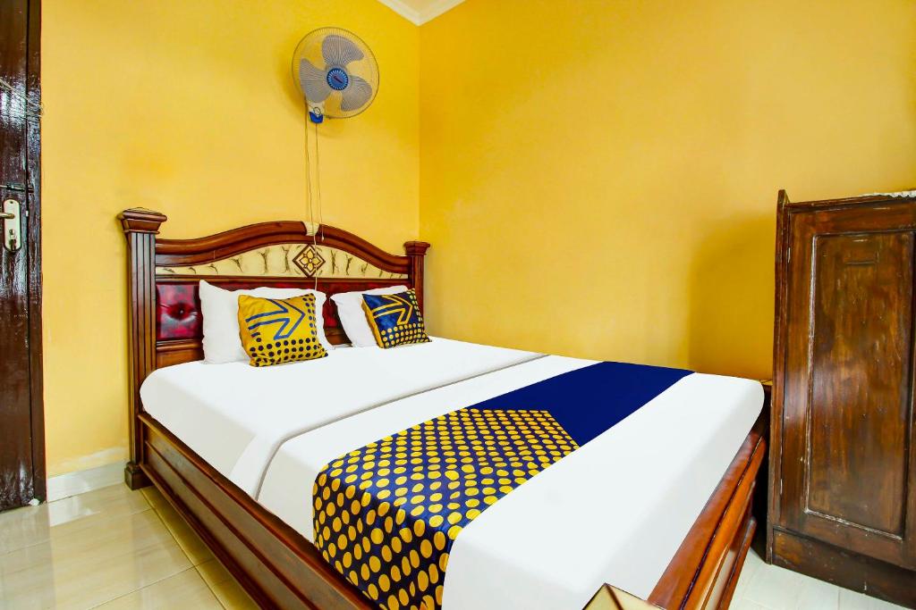 MandirancanOYO HOMES 91242 Desa Wisata Cibuntu Kuningan Syariah的一间卧室设有两张黄色墙壁的床